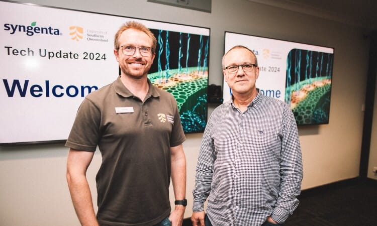 Two men stand in front of a screen displaying "Tech Update 2024" and "Welcome" at a Syngenta and University of Southern Queensland event.