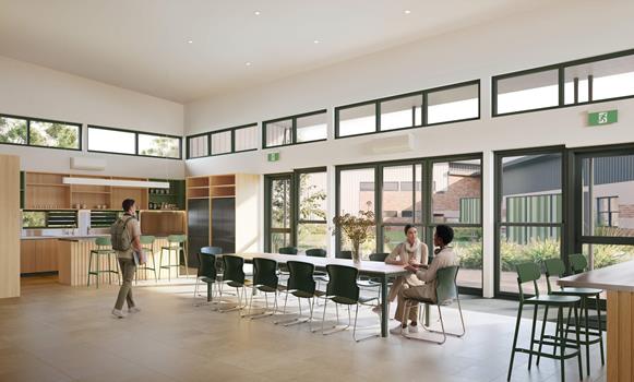 Modern communal kitchen and dining area with large windows, furnishings and natural light.