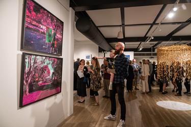 A man looking at a painting on the wall (Park Perspectives: A vision of Laurel Bank Park exhibit).