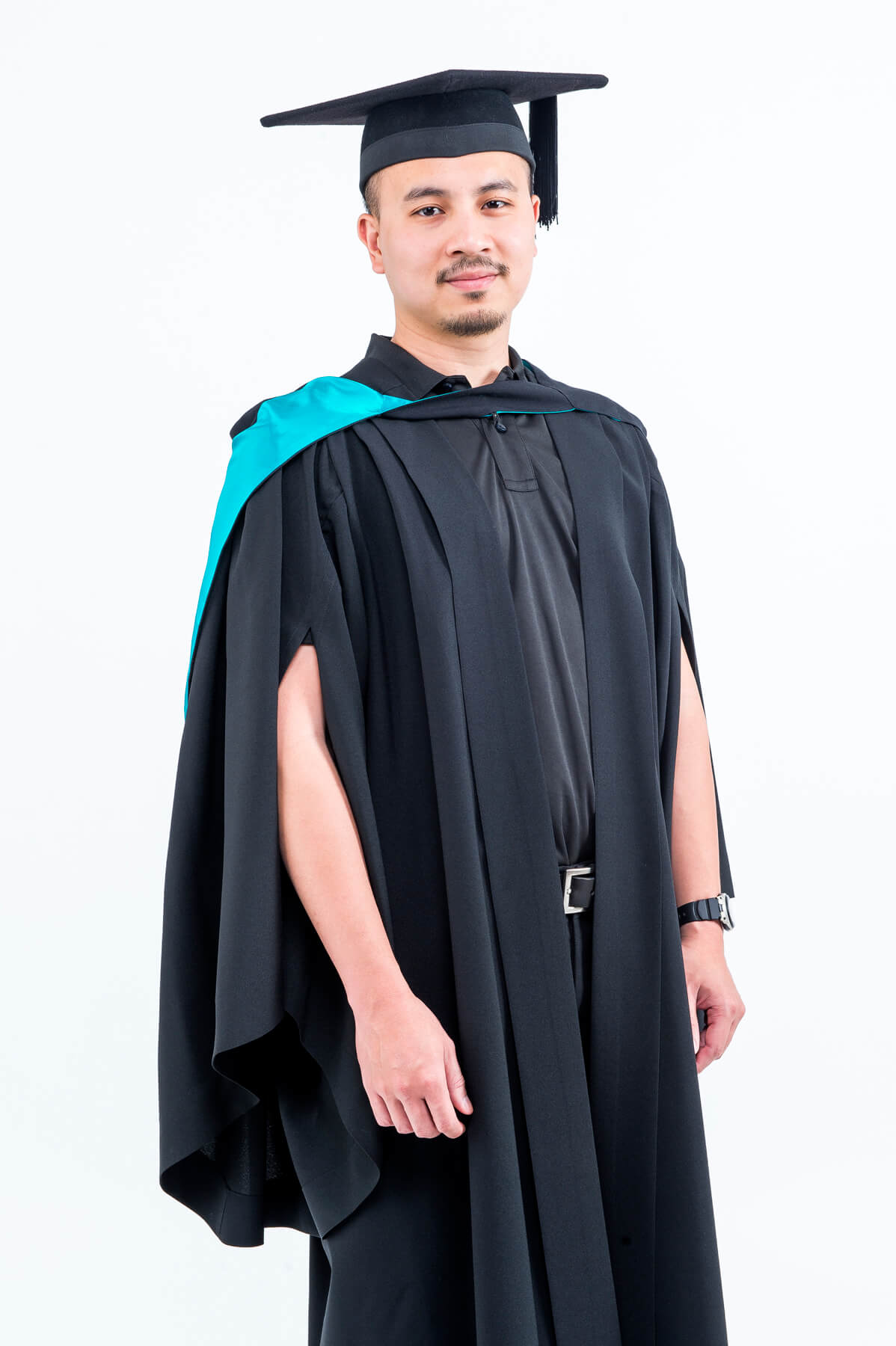 Man in graduation attire smiling at the camera.