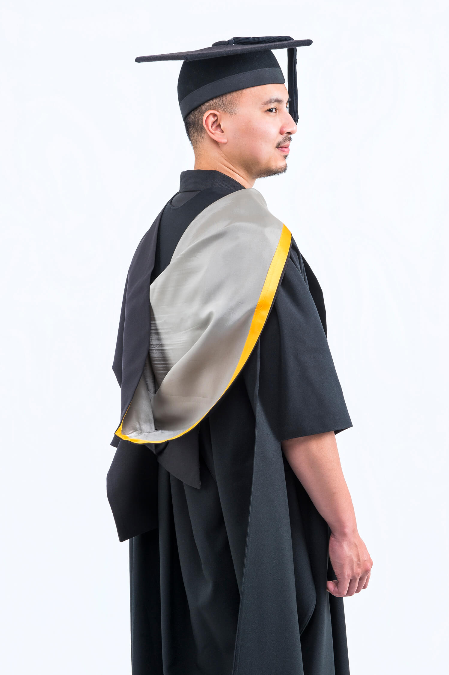 Graduate in cap and gown profile view.