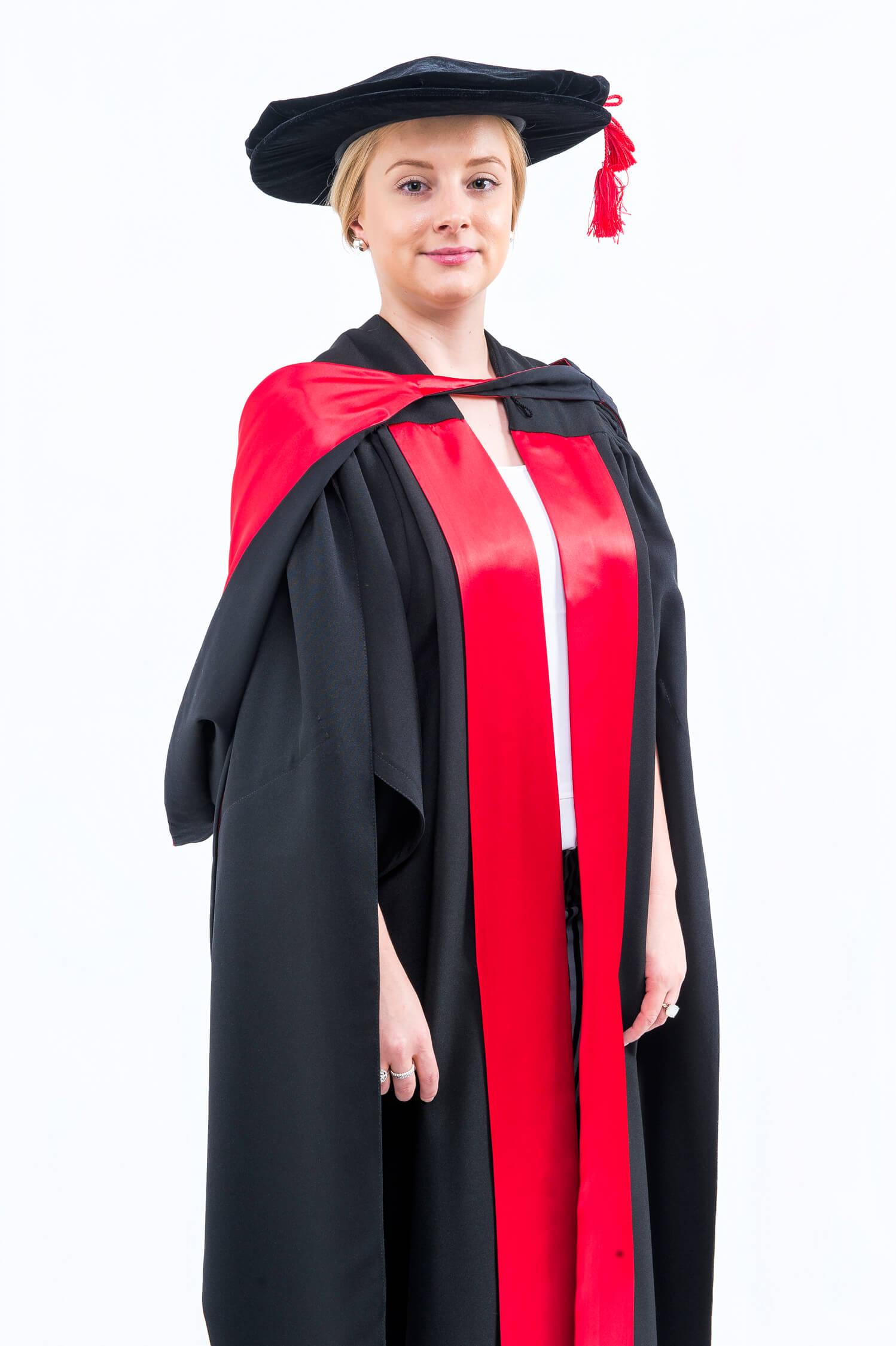 Woman in academic regalia standing against a white background.