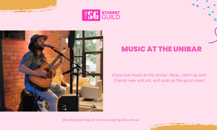 A musician with a beard and hat plays an acoustic guitar and sings on stage at the Unibar; event details and Student Guild info are displayed.