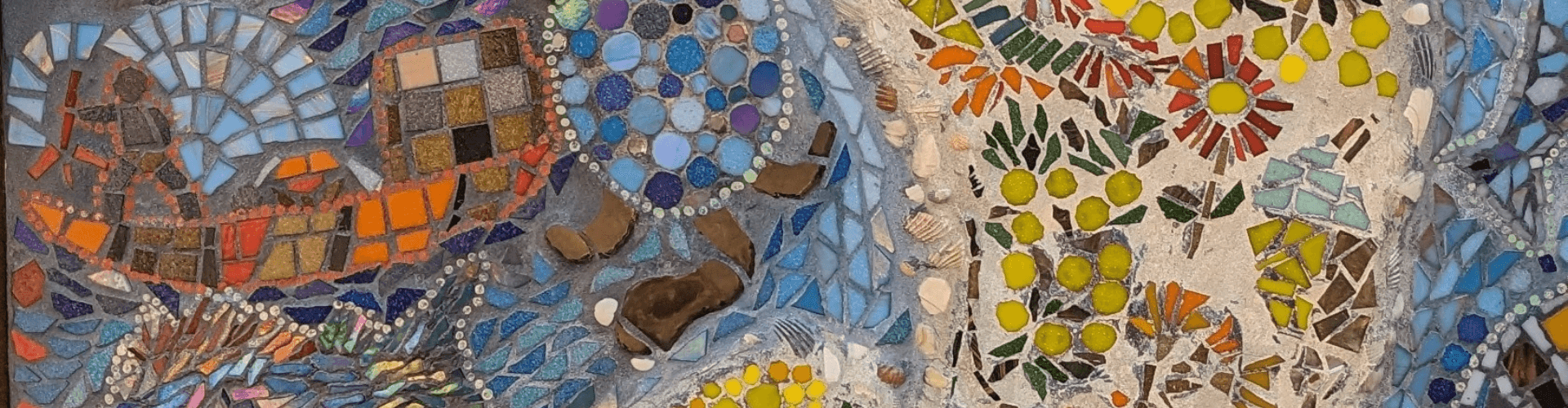 Colorful mosaic artwork featuring abstract shapes and patterns with blue, orange, yellow, green tiles, and small stones and shells embedded in the design.