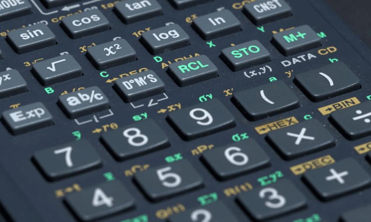 Close-up of a scientific calculator keypad showing various buttons with mathematical functions, numbers, and symbols in white, green, yellow, and orange text.
