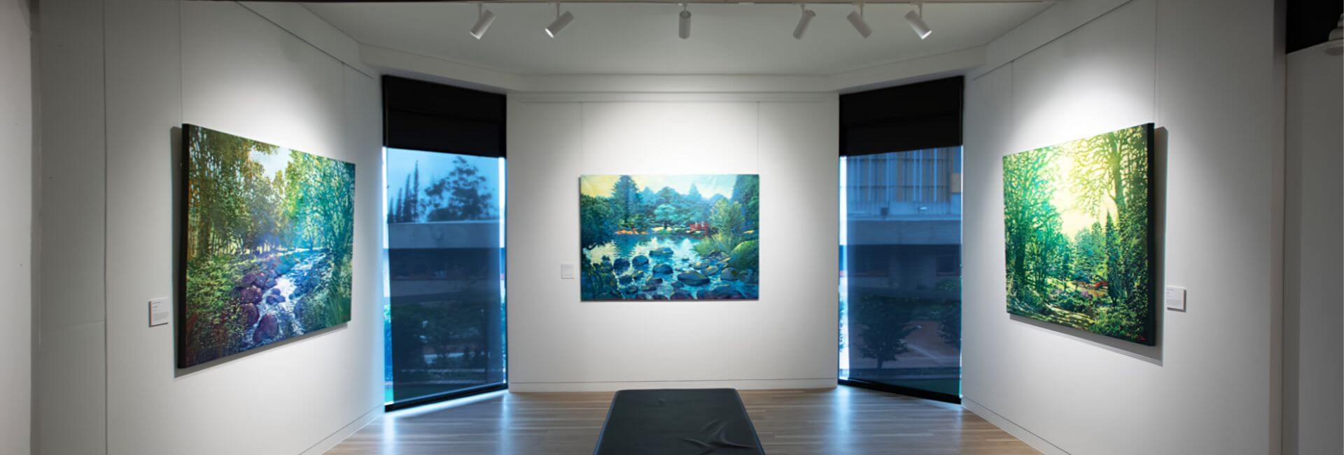 An art gallery, three paintings featured.