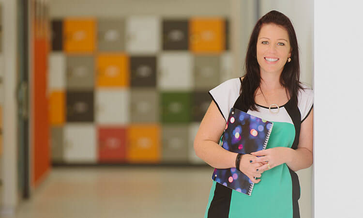 Professional woman holding a notebook in an office environment.