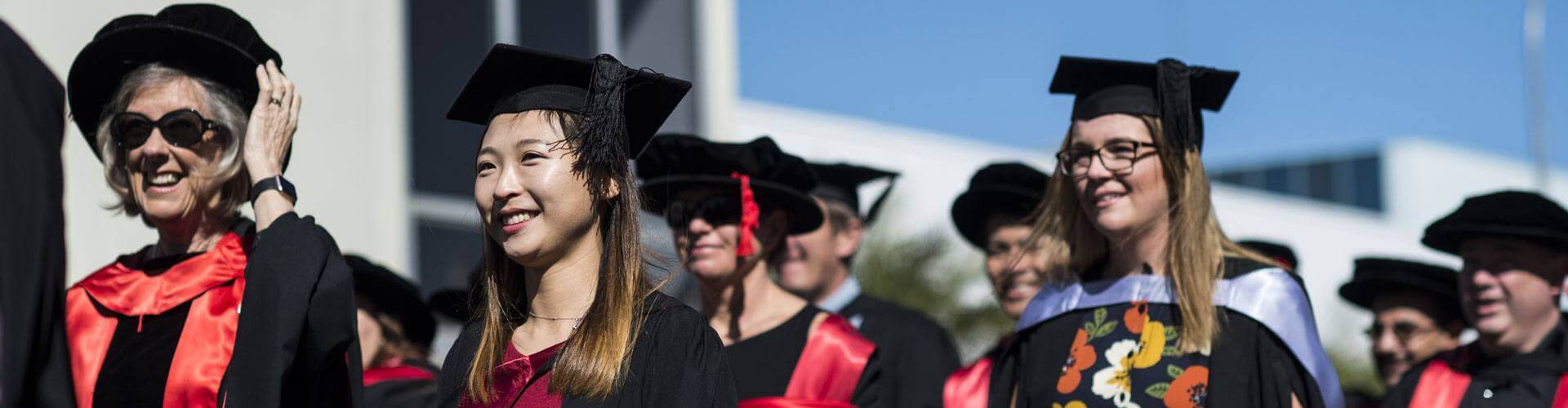 Graduates in cap and gown celebrating commencement day.