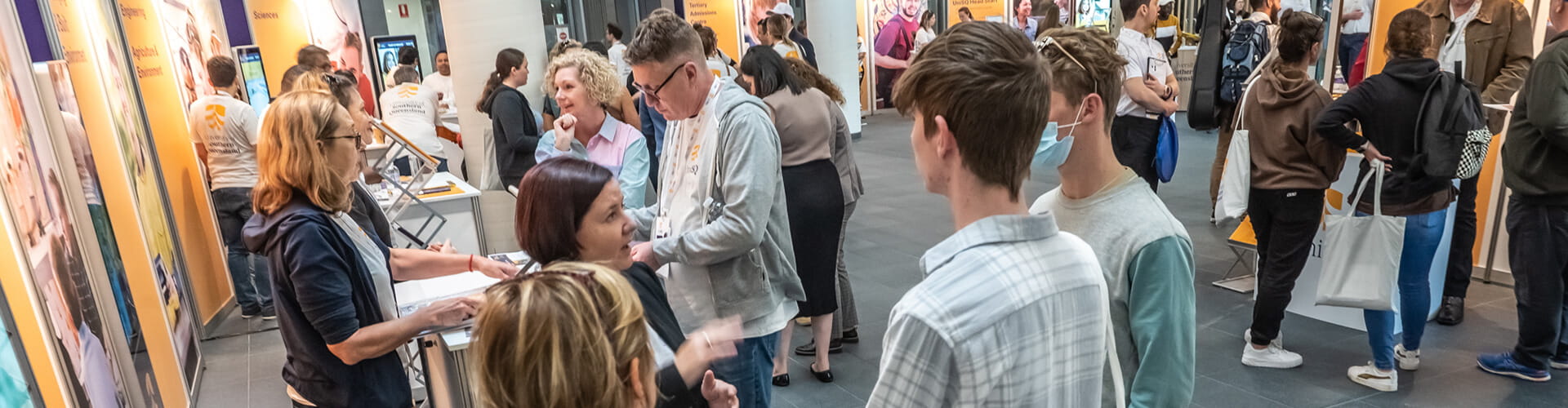 UniSQ staff speaking with prospective students at UniSQ Springfield.