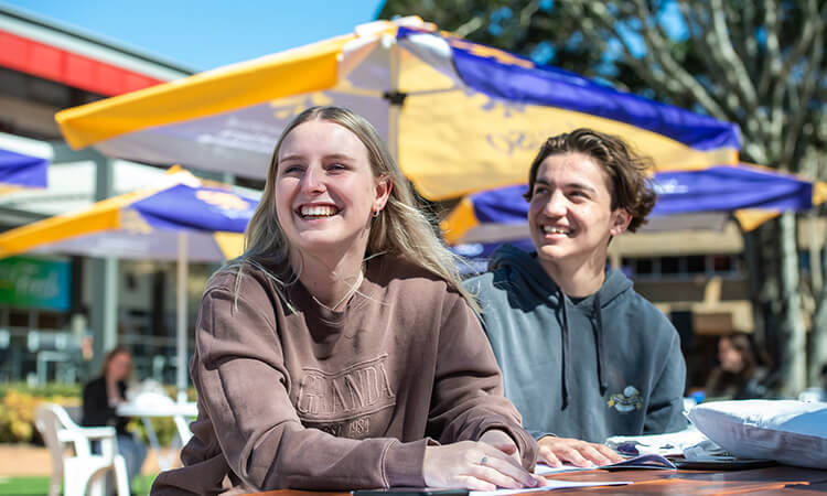 Two students sitting at the UniSQ Toowoomba campus.