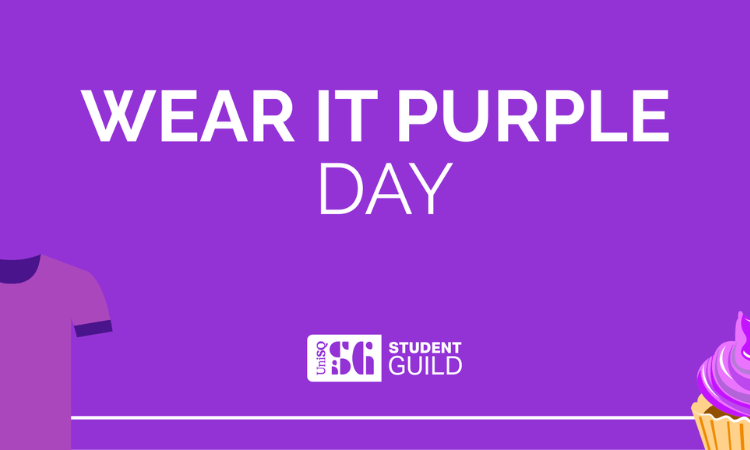 Banner with "Wear It Purple Day" text, purple background, partial illustration of a purple shirt on the left, and a purple cupcake on the right. UniSQ Student Guild logo at the bottom.