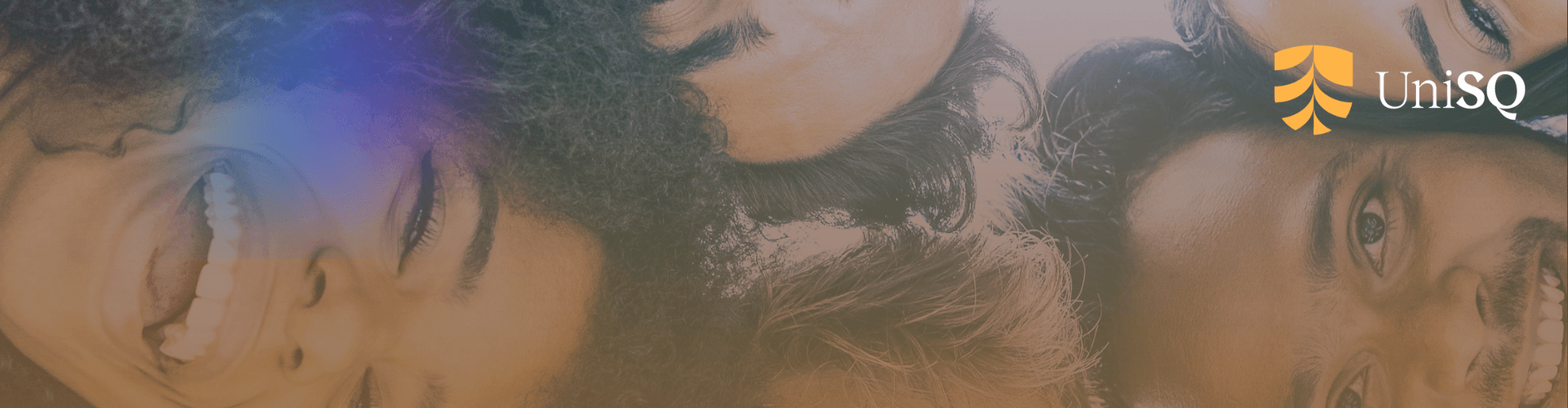 Four people lying together in a circle, smiling and looking up, with the UniSQ logo in the top right corner.