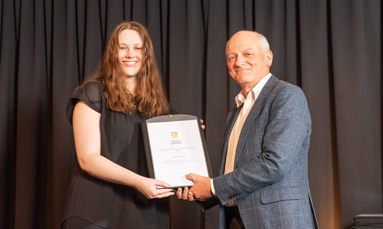 A woman receiving an award from a man onstage.