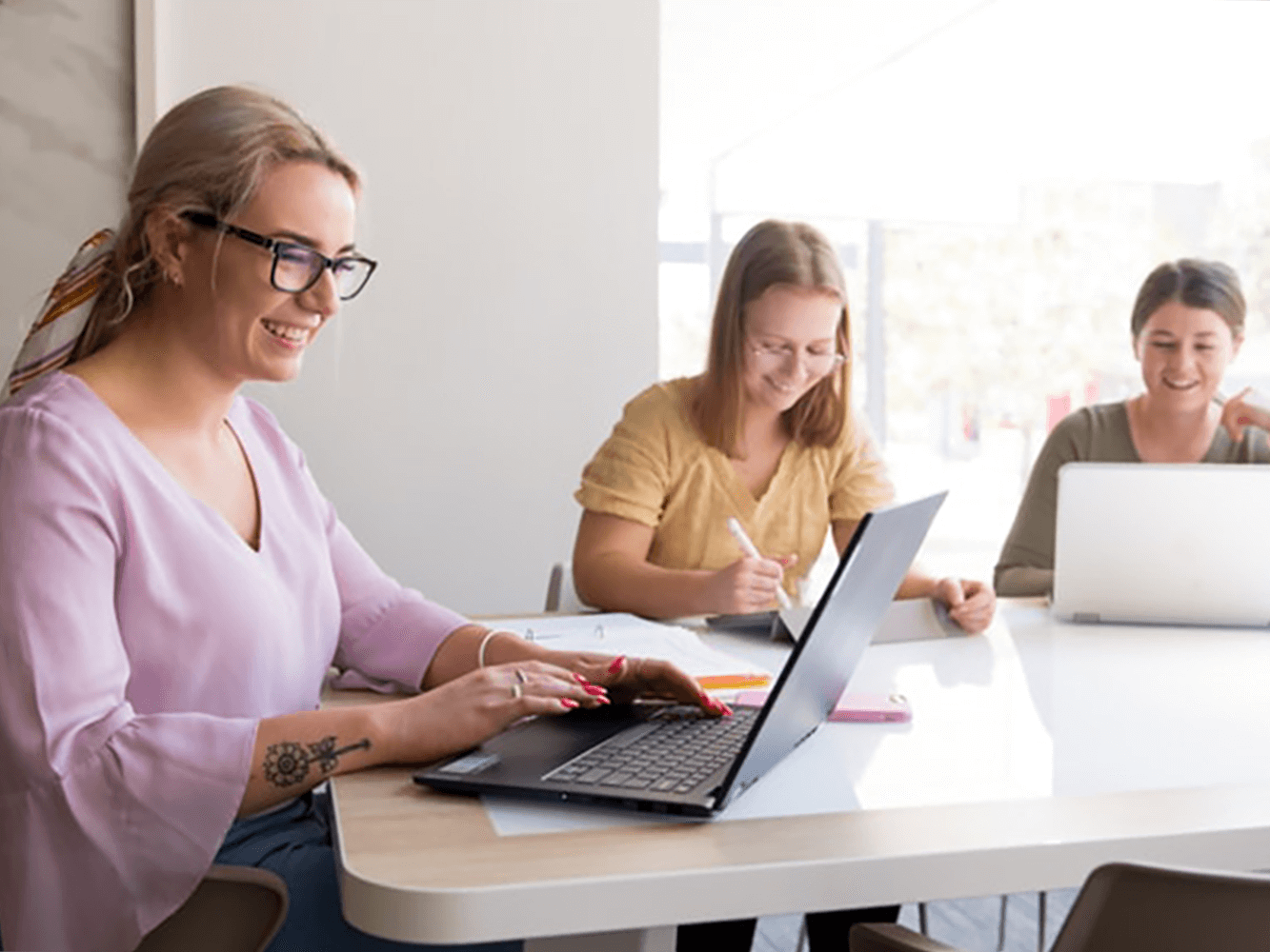 Students sitting at desk with laptops