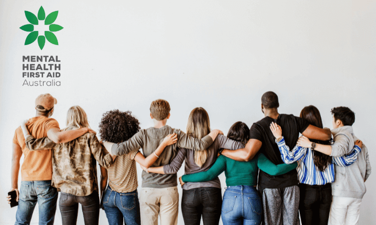 A diverse group of people stand in a line facing a wall with arms around each other, next to the Mental Health First Aid Australia logo.