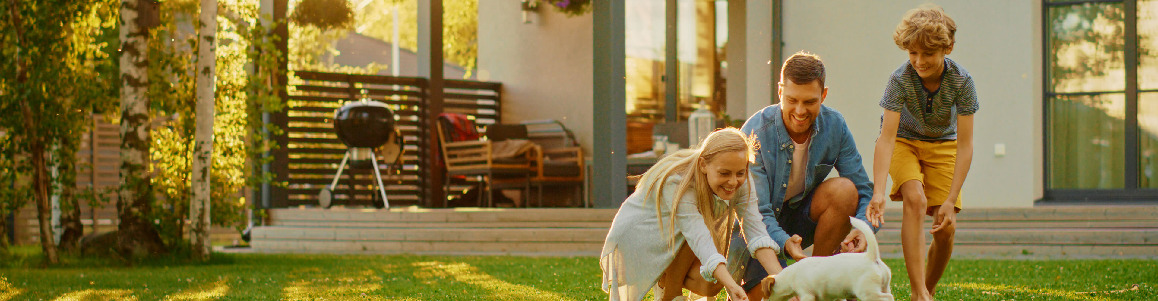 A family playing with their puppy in the backyard.