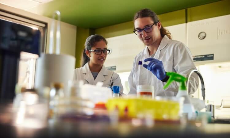 Two scientists in lab coats conducting research in a laboratory.