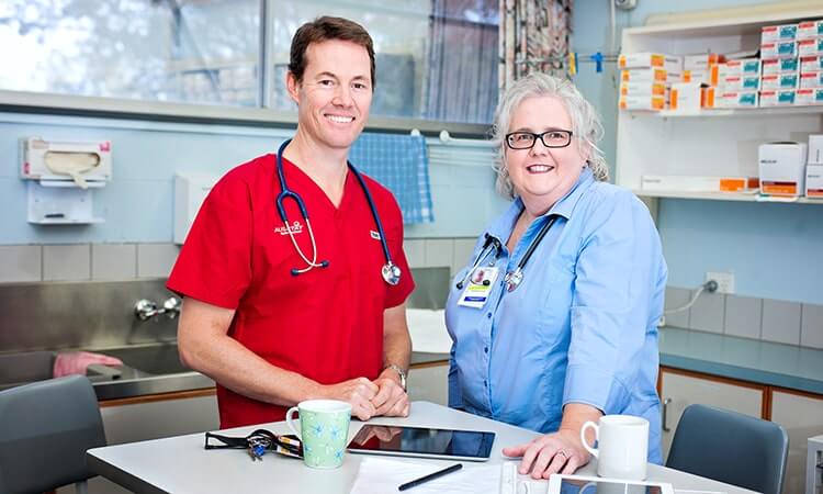 Two healthcare professionals smiling in a medical office.