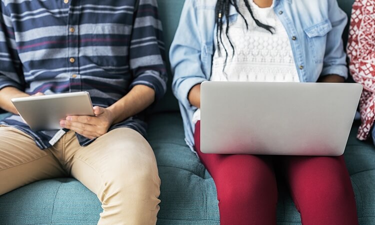 Students working side by side on laptops