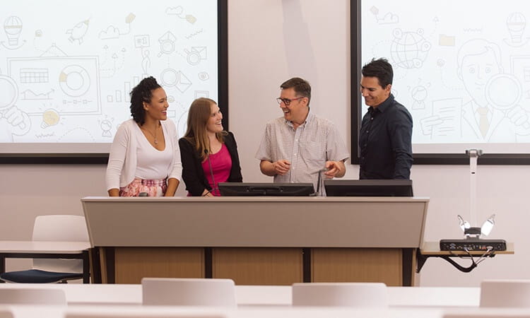 Colleagues holding a discussion around a lectern