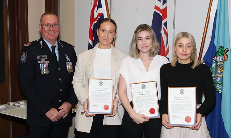 three usq students being awarded by acting assistant commissioner 