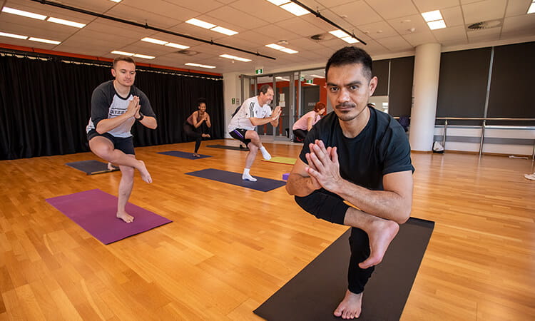 yoga instructor holding pose in class