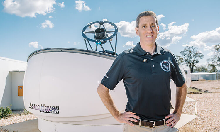 man in front of telescope