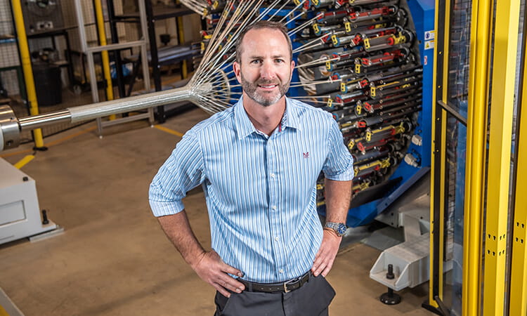 man smiling at camera with his hands on his hips