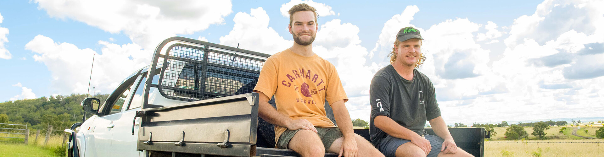 Two people sitting on back of ute