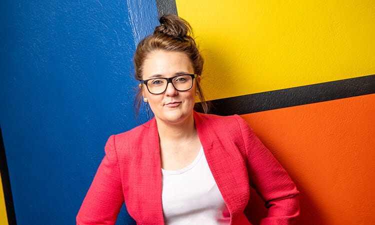 woman in front of colourful wall