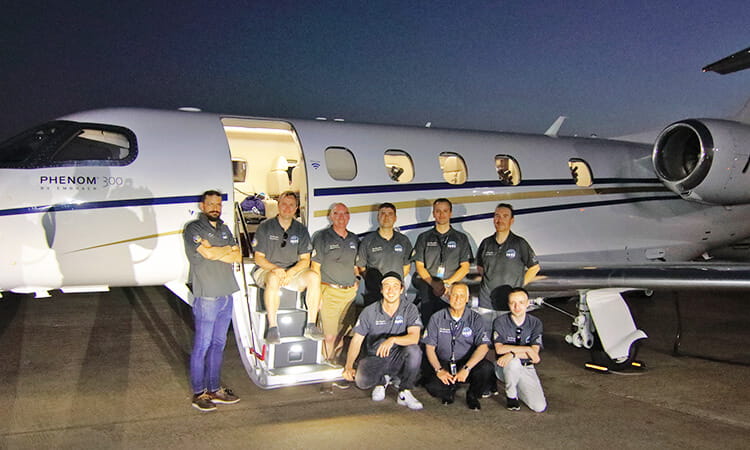 scientists in front of a plane 