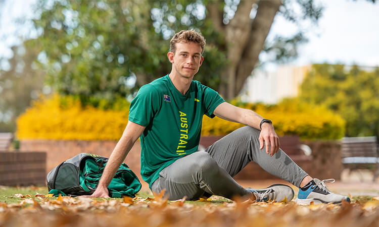 boy sitting down on the grass 