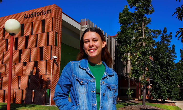 girl smiling in front of auditorium