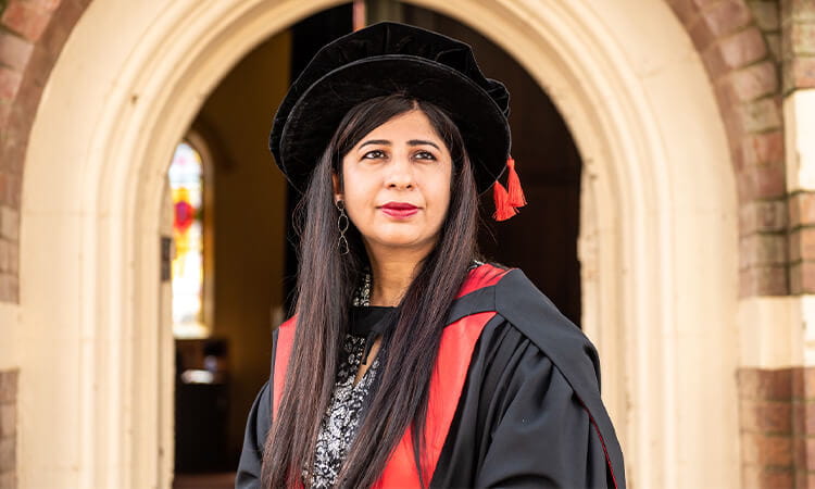 grad smiles in gown and cap