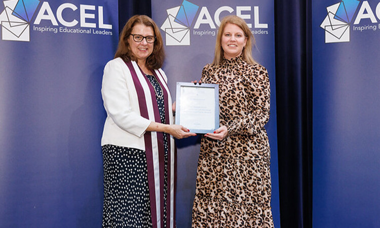 Two women holding an award.