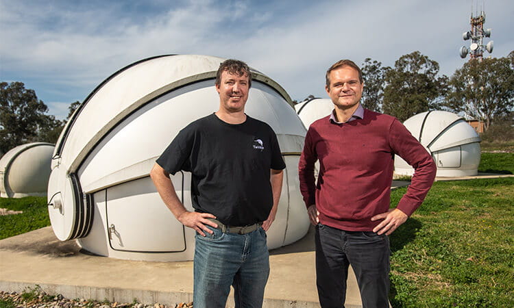 men standing in front of telescope