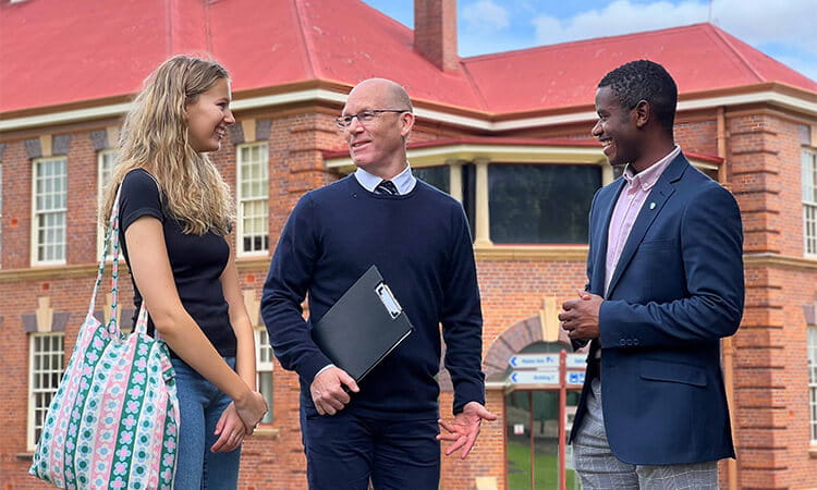 A woman standing with two men.