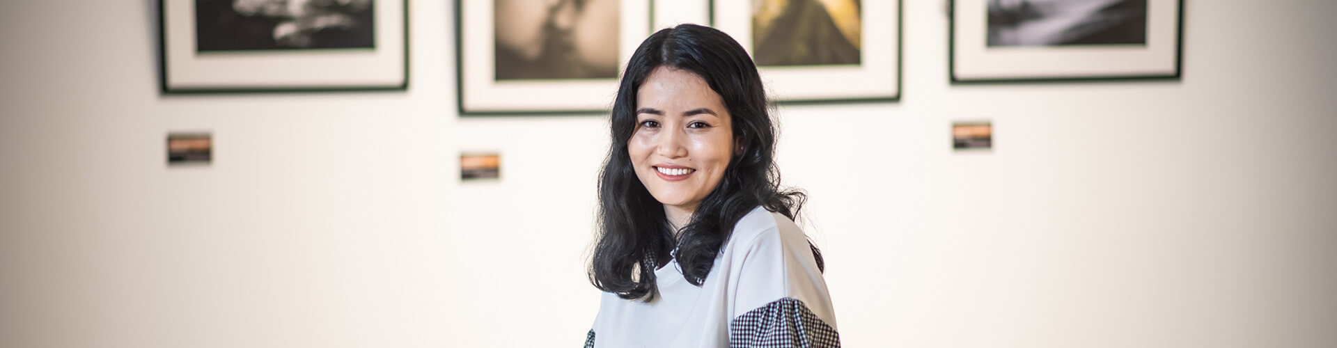 girl smiling in front of artwork 
