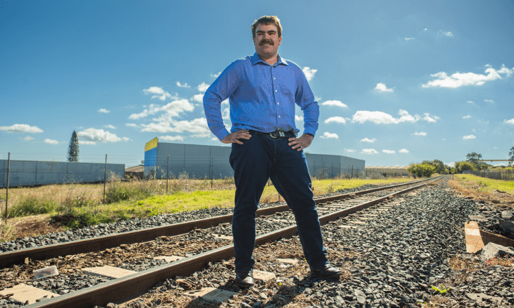 Man standing next to train track.