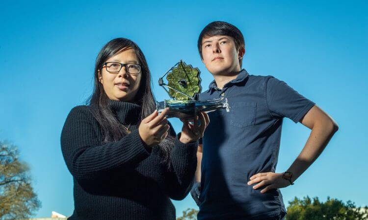 two researchers holding space exploration object