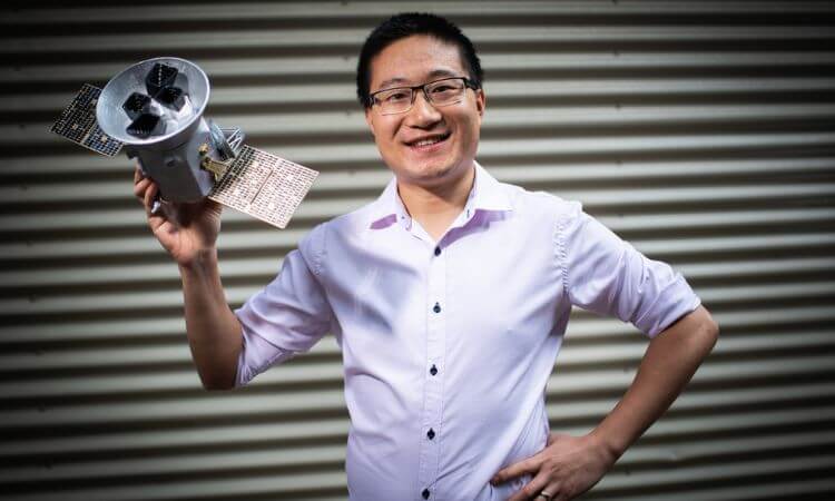 man holding a mini-satellite type device