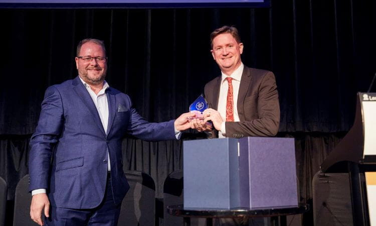 two men shake hands on stage 