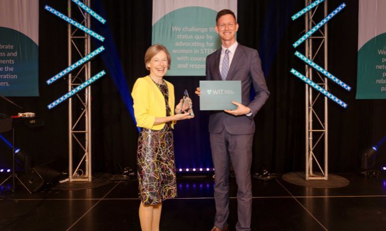 woman and man with an award on stage 