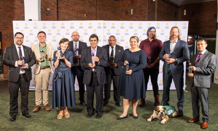 people standing with trophies