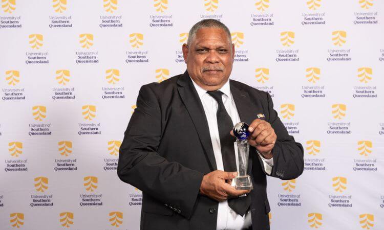 man holding trophy in a suit 