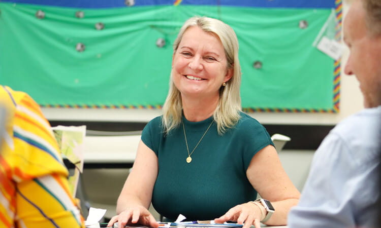 woman sitting at desk smiling 