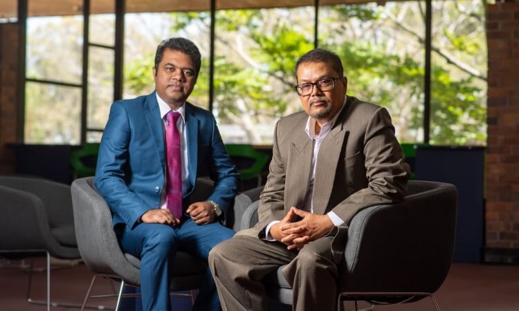 Two men sitting in Library.