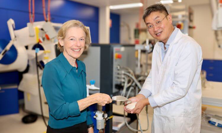 woman and man in a lab smiling at the camera 