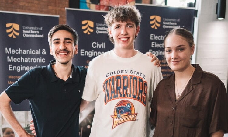 Three people posing for a photo at an event.