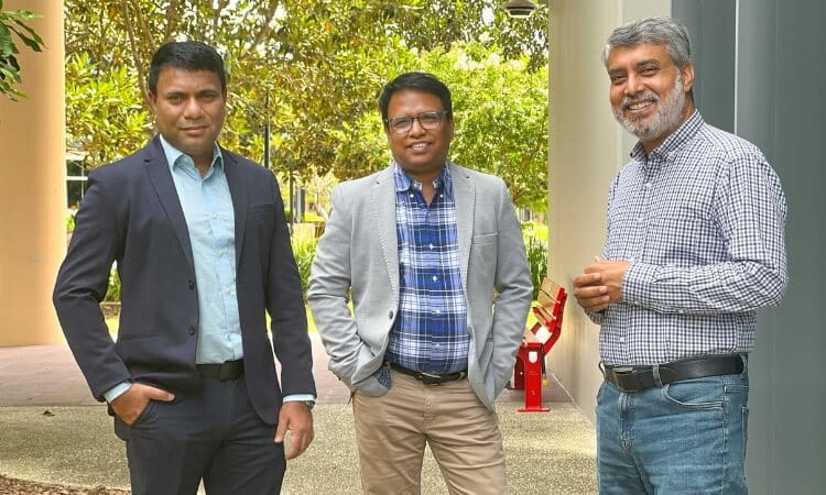 Three men in semi-casual attire posing for a photo.